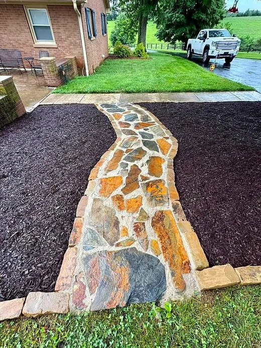 Finished flagstone walkway set in dark mulch beds after service