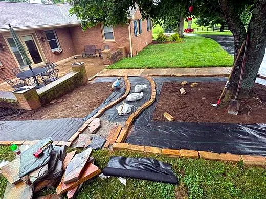 Flagstone walkway under construction with tools on site