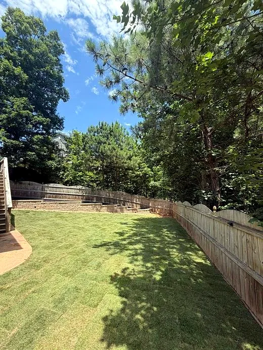 Backyard lawn with retaining wall and privacy fence